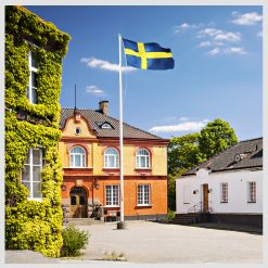 Flaggstång med svensk flagga hissad utanför hotell